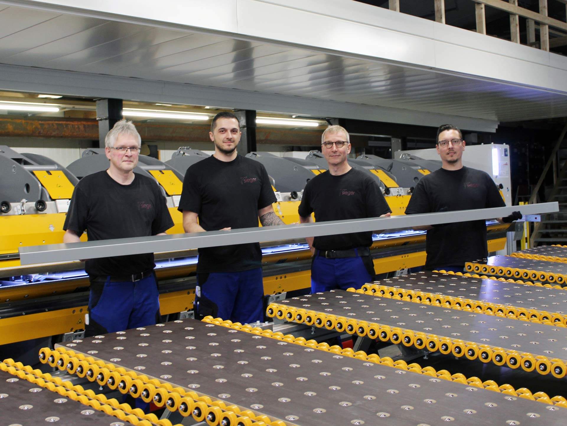 HOCHZUFRIEDEN: Firmenchef Jürgen Sieger (zweiter von rechts) und sein Team sind mit dem Biegeresultat hochzufrieden und präsentieren stolz ein vollautomatisch hergestelltes Blechprofil.
